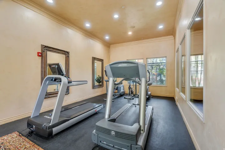 Workout area featuring ornamental molding and recessed lighting