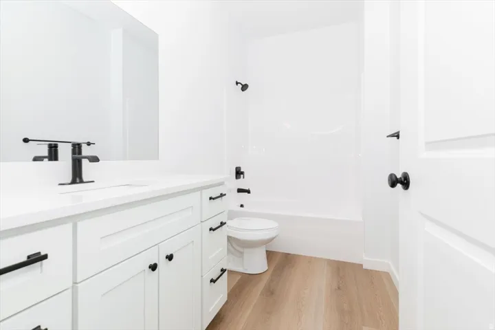Full bath featuring vanity, light wood-style floors, and shower / bathtub combination