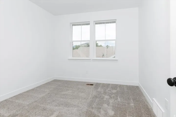 Empty room featuring carpet floors and baseboards