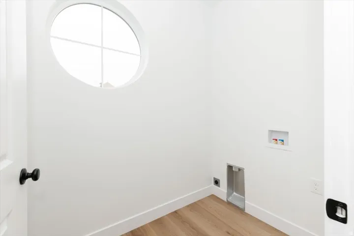Laundry area with light wood-style floors and washer hookup