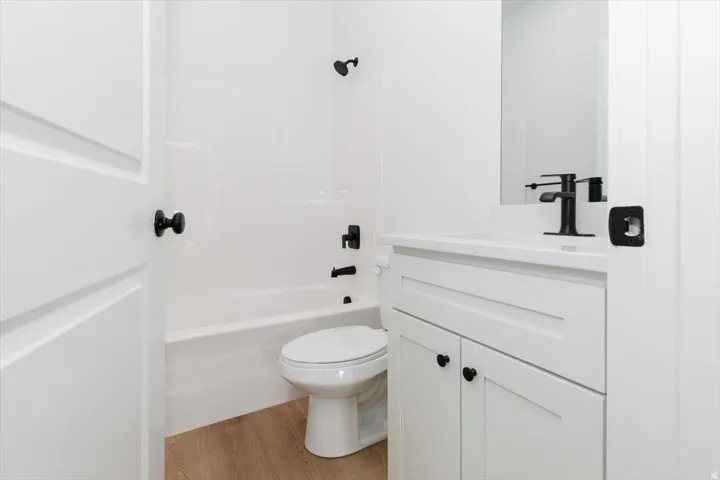 Bathroom featuring vanity, light wood-style flooring, and tub / shower combination