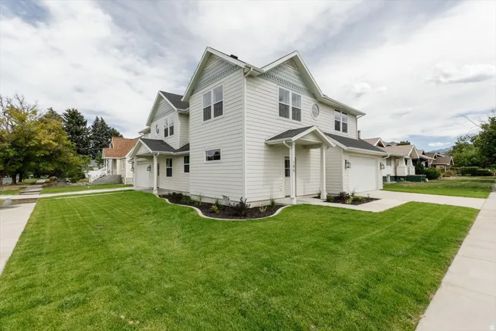 View of property exterior with a yard, driveway, and an attached garage