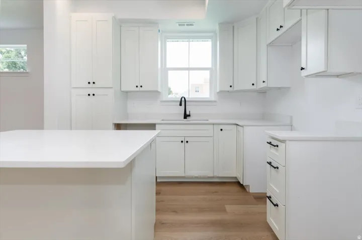 Kitchen with white cabinetry and light wood-type flooring