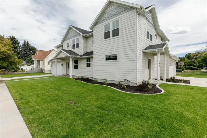 View of front facade with a garage, a front yard, and concrete driveway
