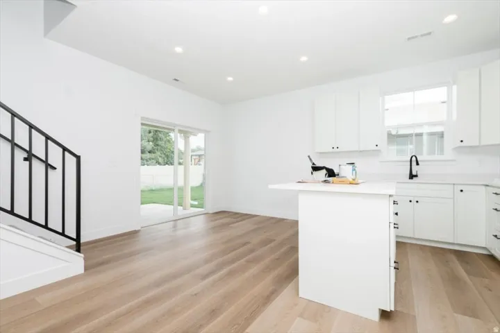 Kitchen featuring white cabinets, recessed lighting, light wood-style floors, and a kitchen island