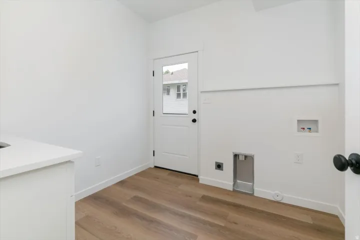 Laundry room featuring light wood finished floors, hookup for a washing machine, and hookup for an electric dryer