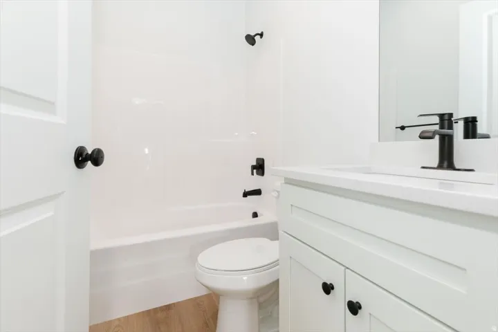 Bathroom featuring vanity, light wood-style floors, and  shower combination