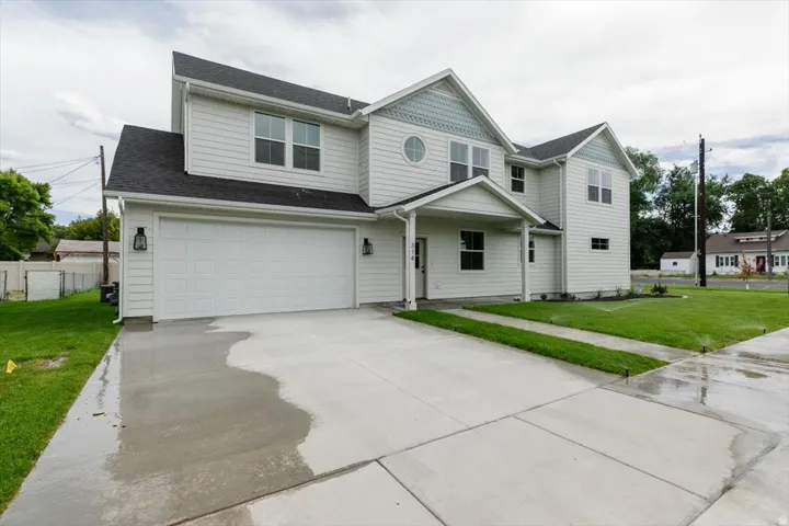 View of front facade featuring concrete driveway, an attached garage, and roof with shingles