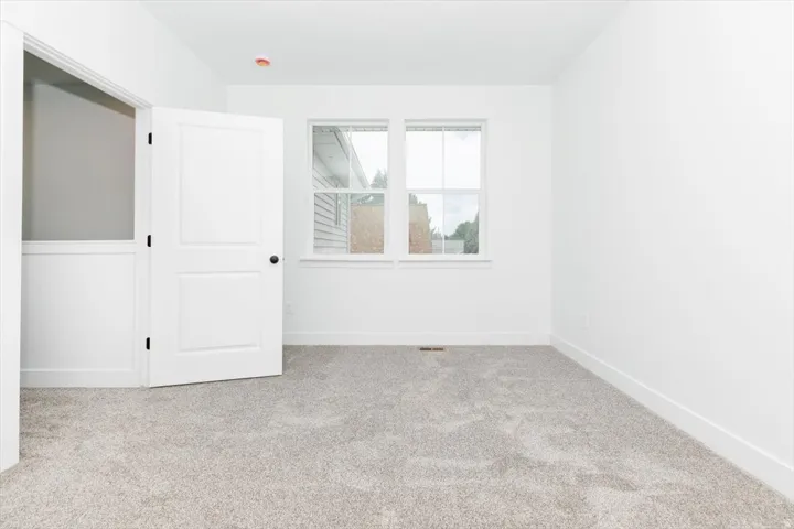 Spare room with light colored carpet and baseboards