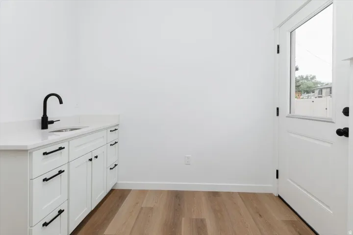 Laundry room featuring light wood-style flooring and a sink