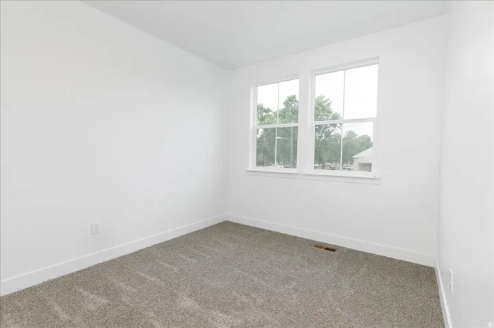 Spare room with carpet and baseboards