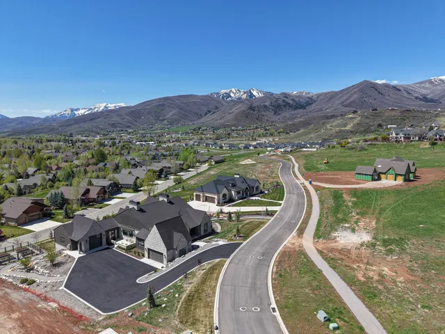 Aerial view of property's location with a mountain backdrop and nearby suburban area