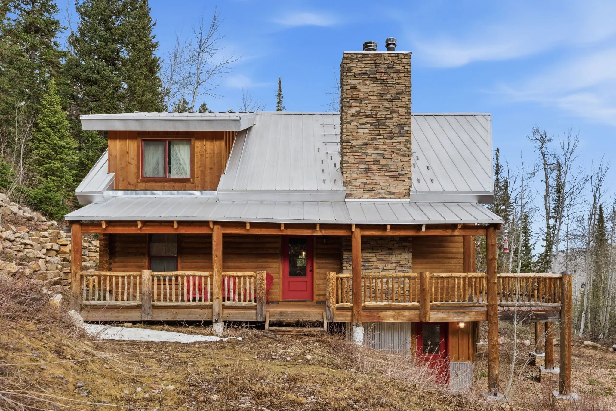 View of front of home featuring a chimney, covered porch, and a metal roof