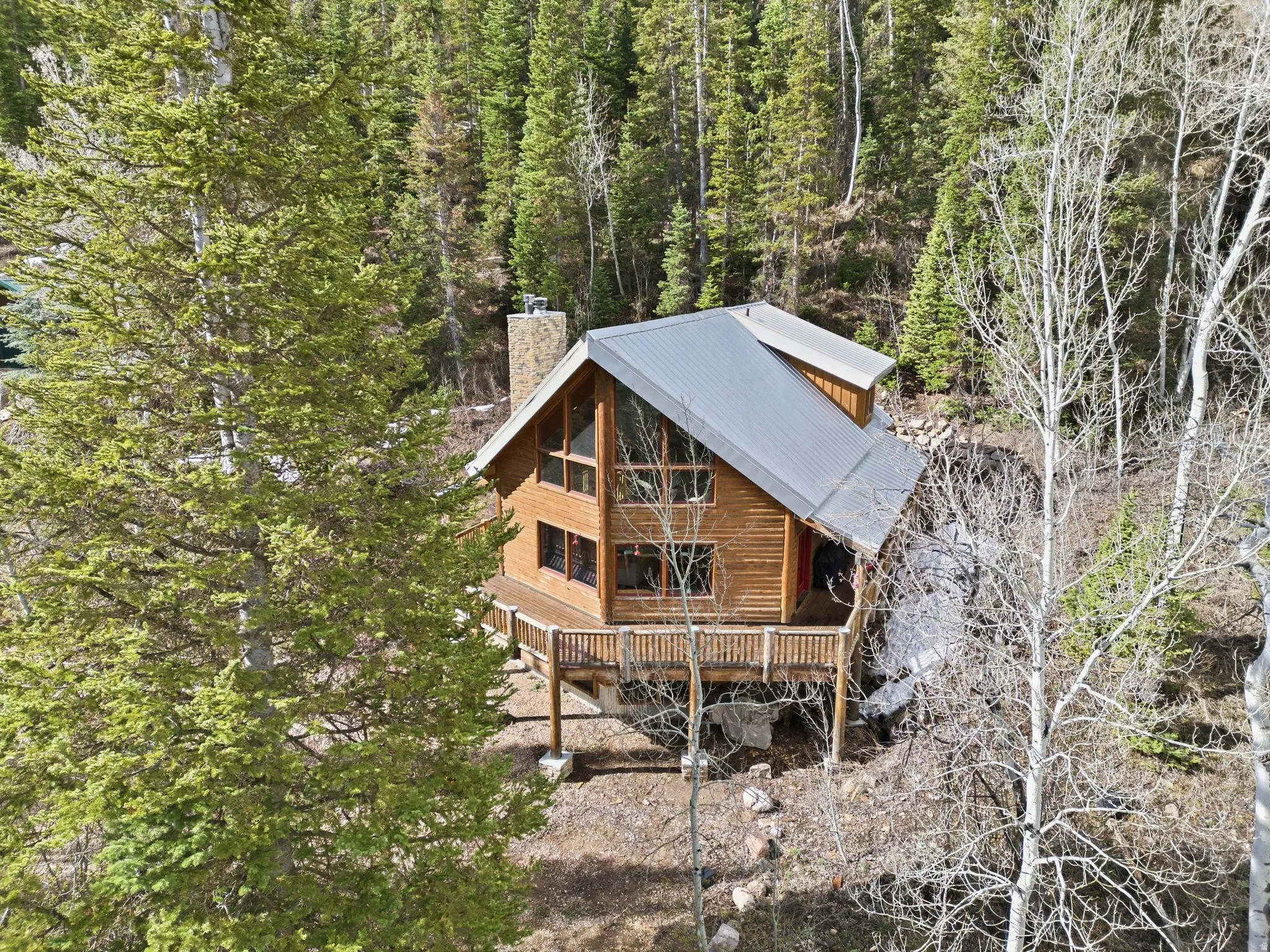 Back of property featuring a chimney and a metal roof