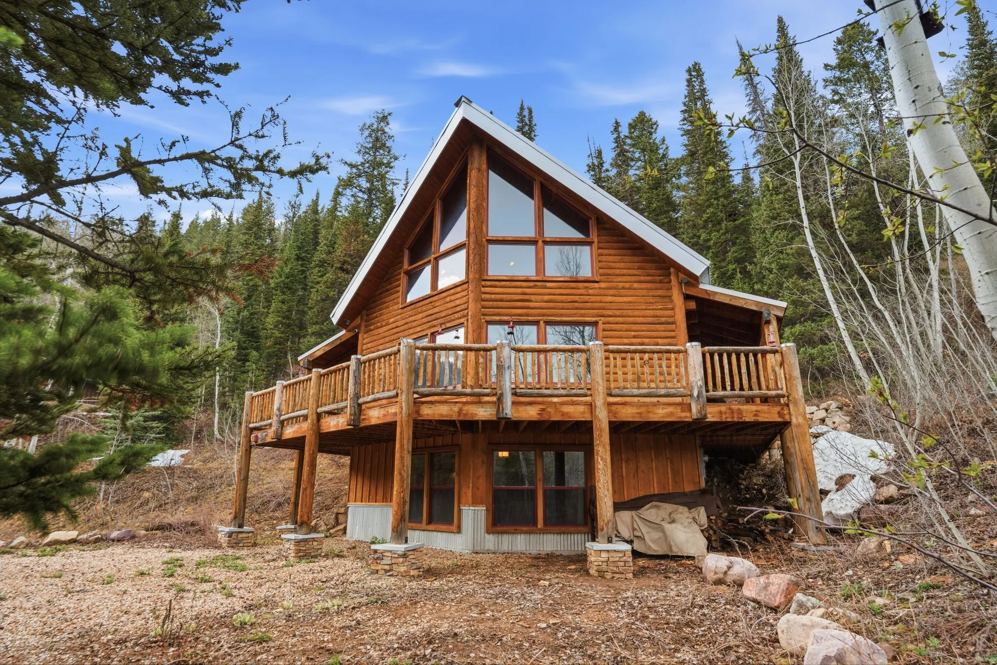 Back of property with a wooden deck and faux log siding