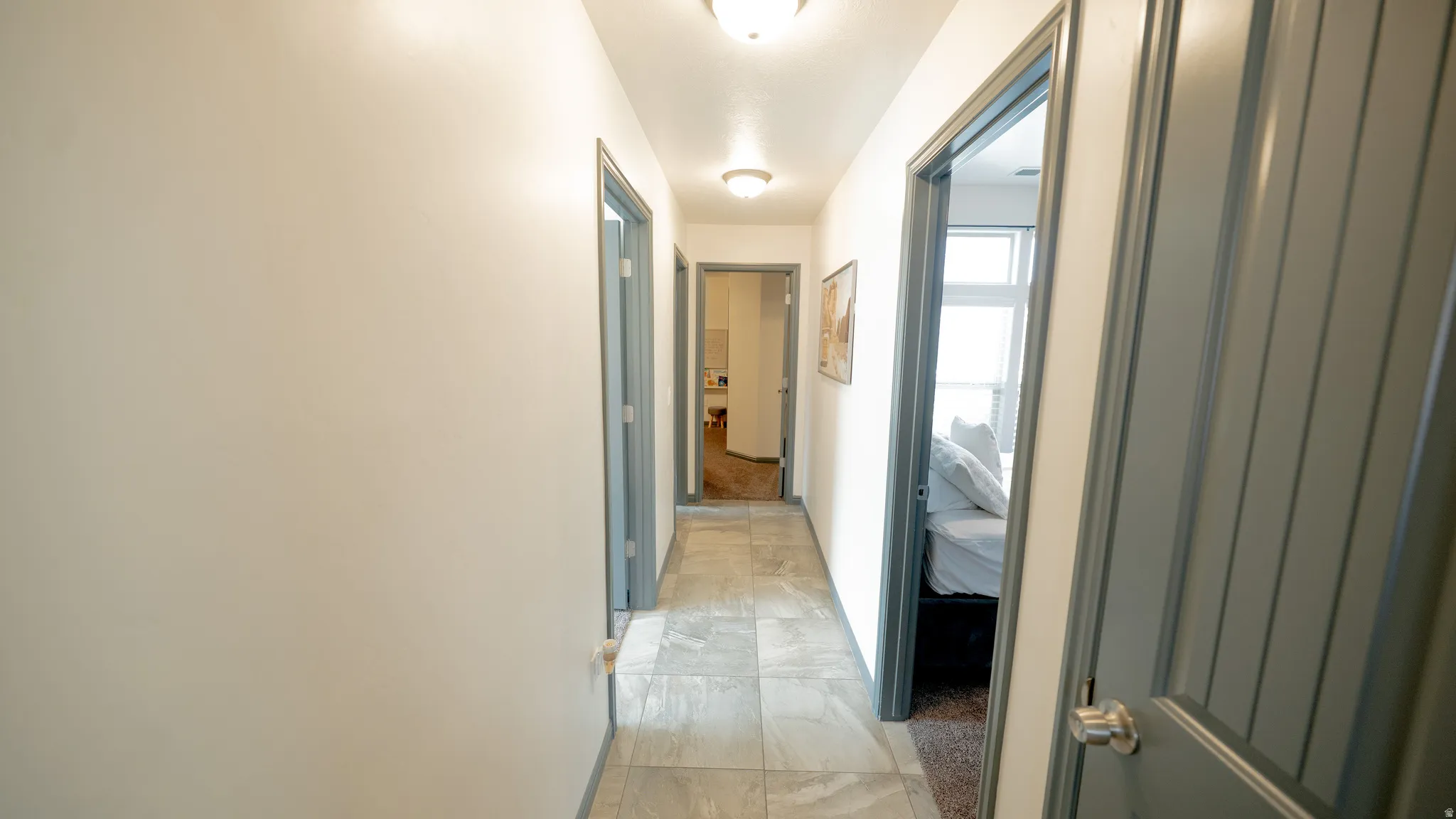 Hallway with baseboards and light marble finish flooring