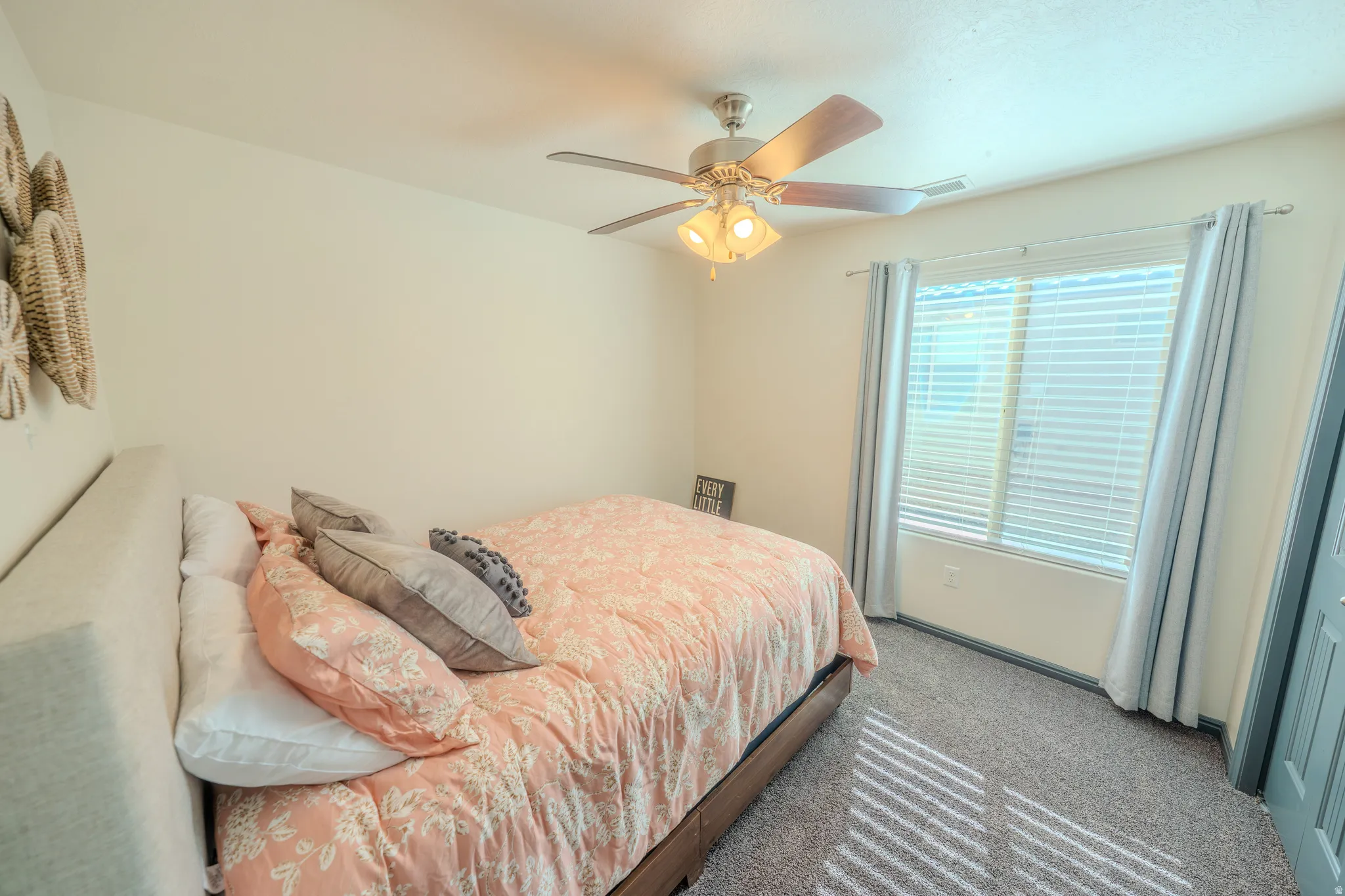 Carpeted bedroom featuring ceiling fan