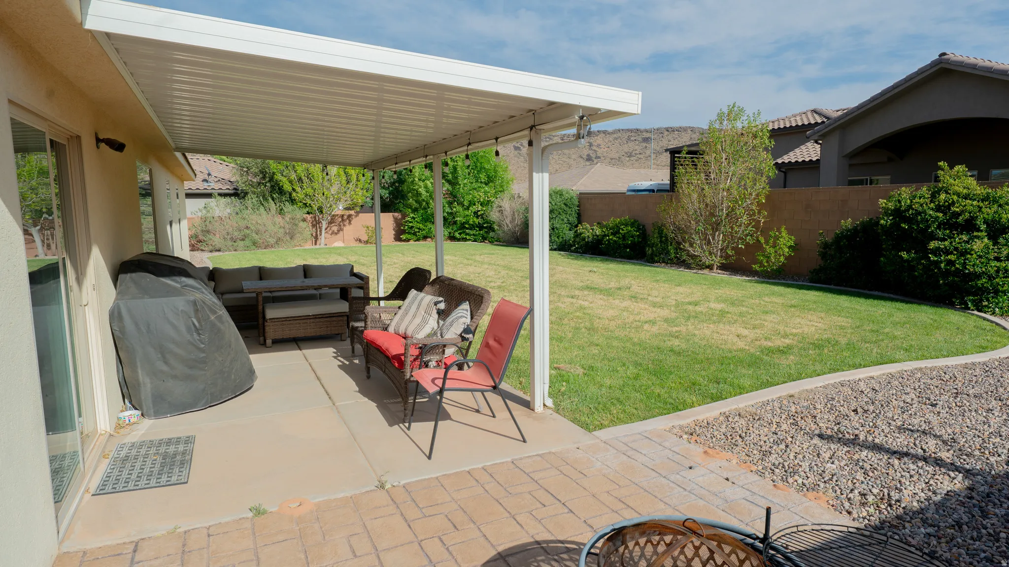 Fenced backyard featuring a patio, an outdoor lounge area, and area for grilling