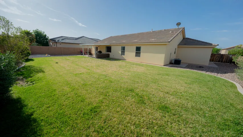 Back of house featuring a fenced backyard, stucco siding, a patio area, and a tiled roof