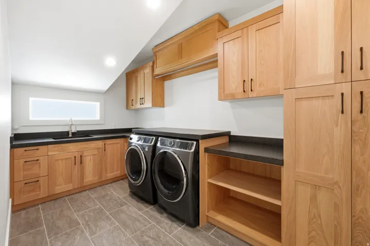 Laundry room featuring separate washer and dryer, cabinet space, and recessed lighting