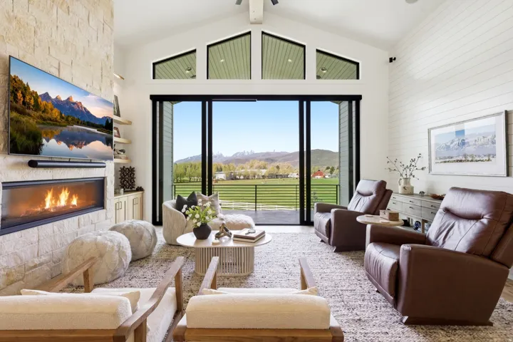 Sitting room featuring a mountain view, a fireplace, a high ceiling, and a ceiling fan
