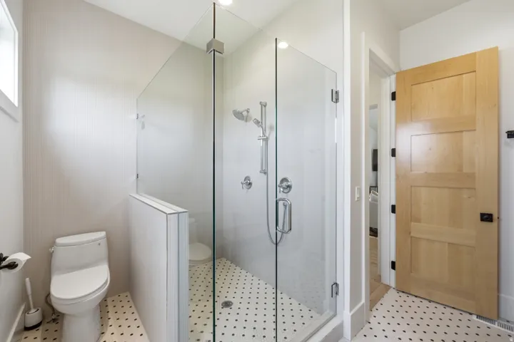 Bathroom with a stall shower and light floors