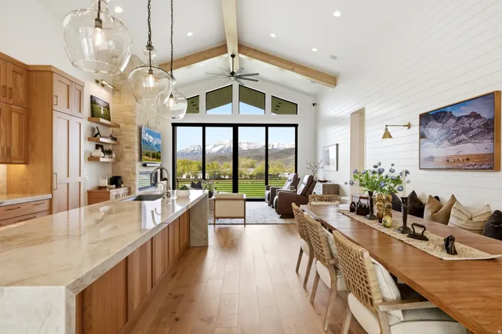 Dining space featuring wooden walls, light wood-style floors, and a ceiling fan