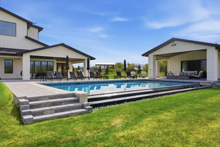 Swimming pool with a patio and a lawn