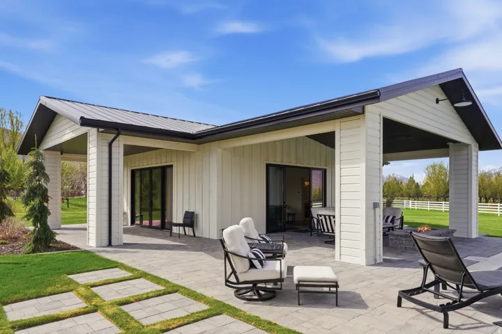 Rear view of property with a patio area, a metal roof, board and batten siding, and exterior bar