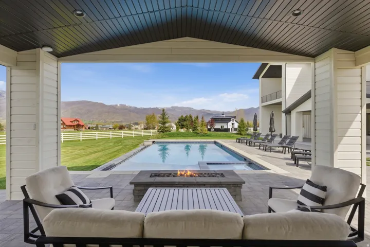 Relaxing pool / spa featuring a patio, a mountain view, and an outdoor fire pit