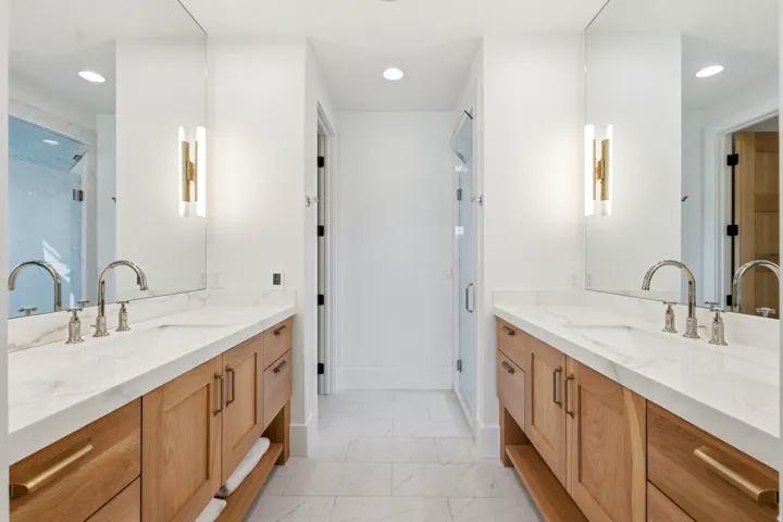 Bathroom featuring two vanities, recessed lighting, and a shower stall