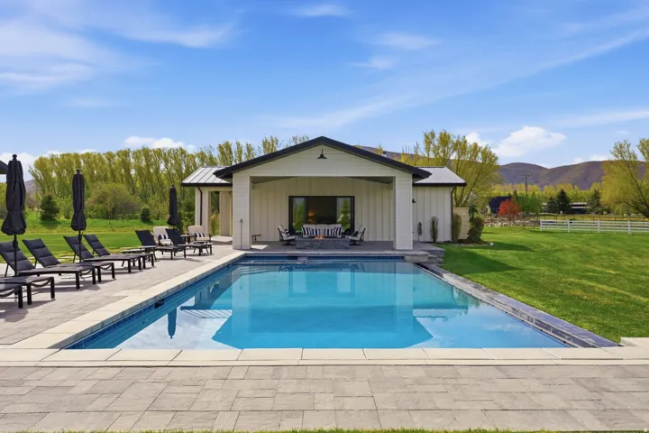 Swimming pool featuring an outbuilding, a patio, an exterior structure, and a mountain view
