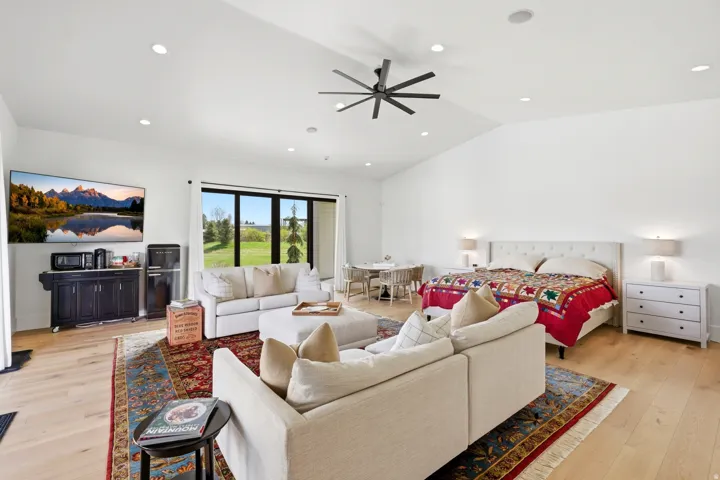 Living room with light wood-style floors, ceiling fan, recessed lighting, and vaulted ceiling