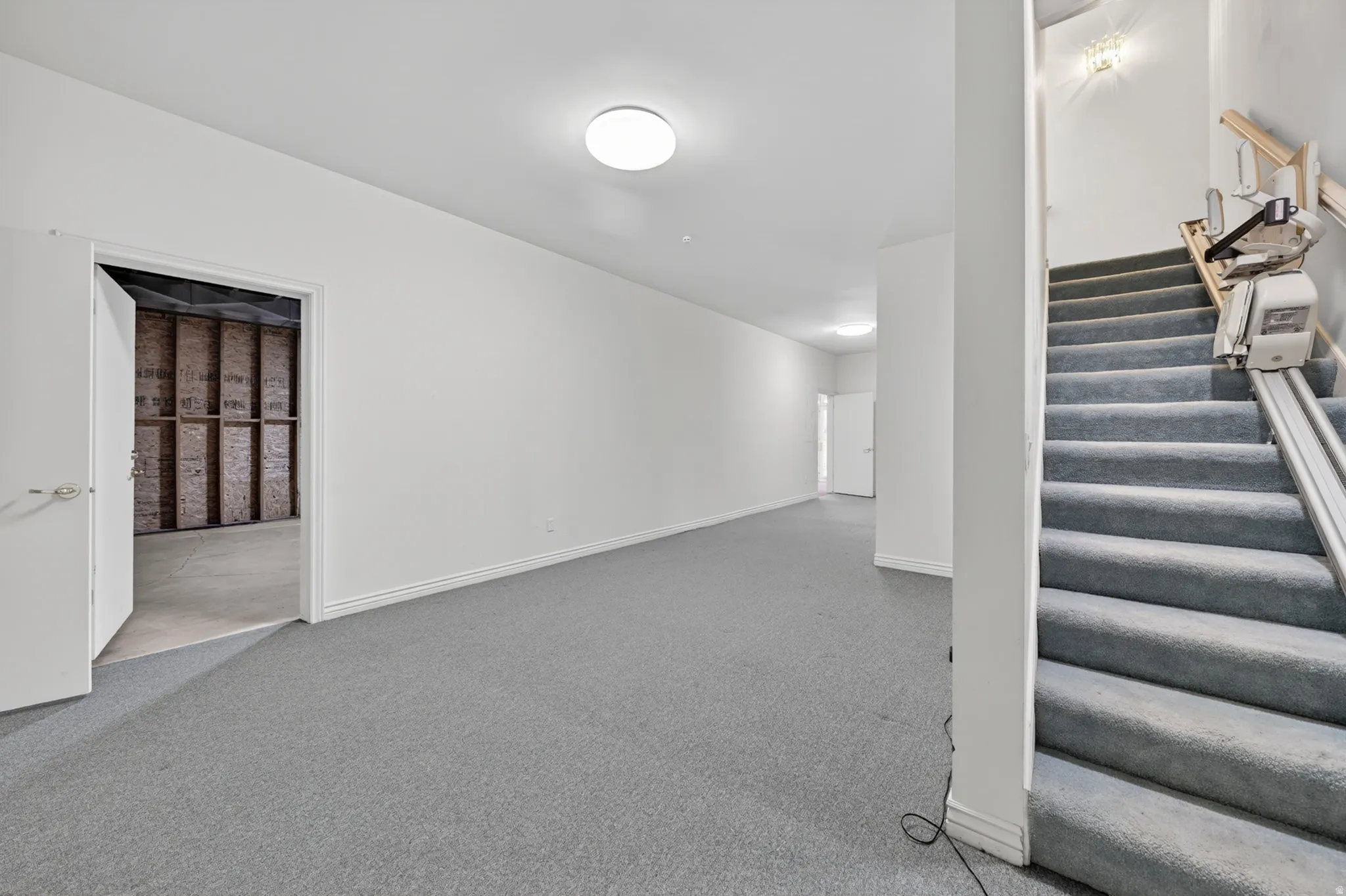 Basement featuring stairway and carpet