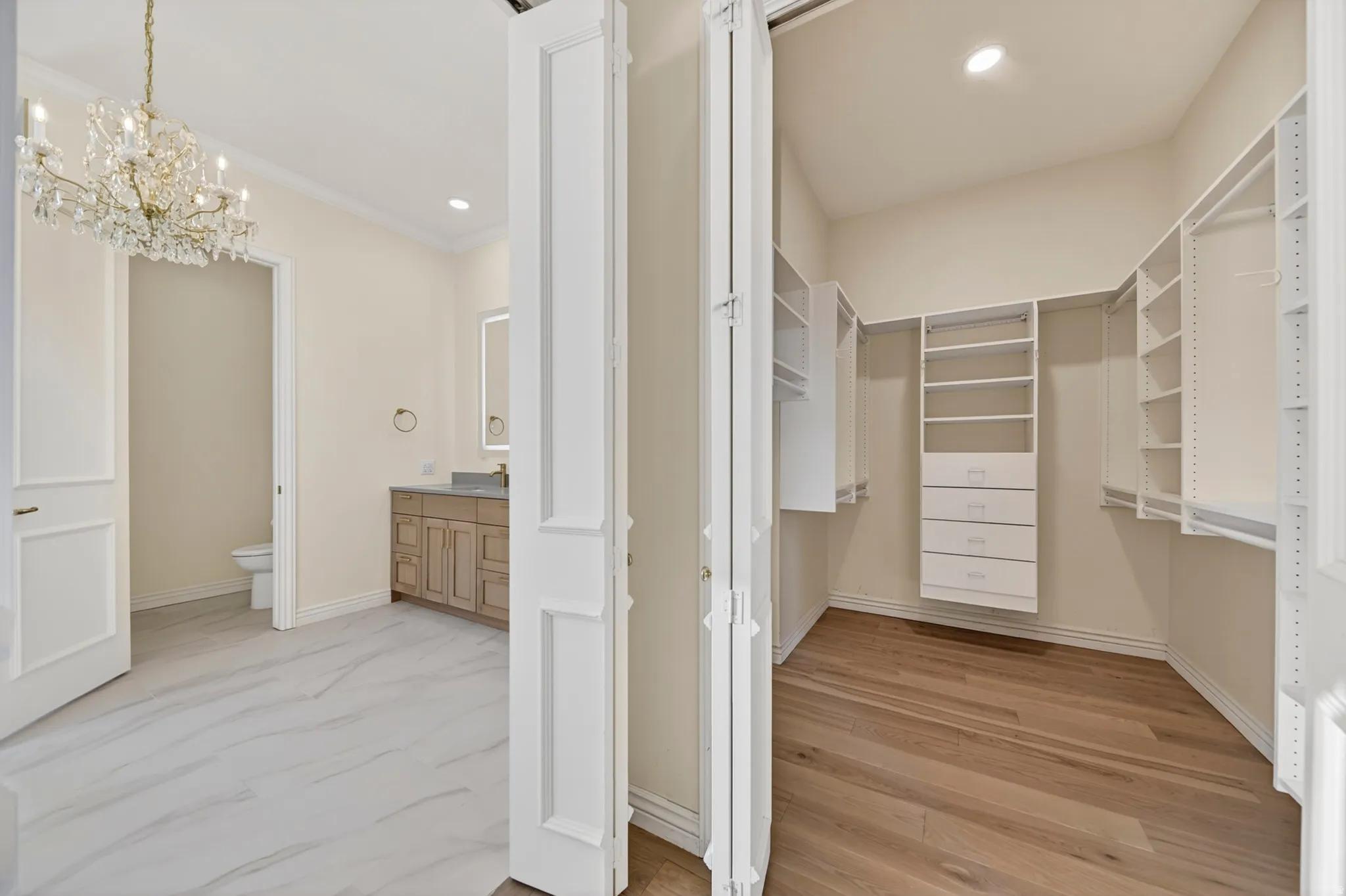 Walk in closet with chandelier in primary suite bathroom