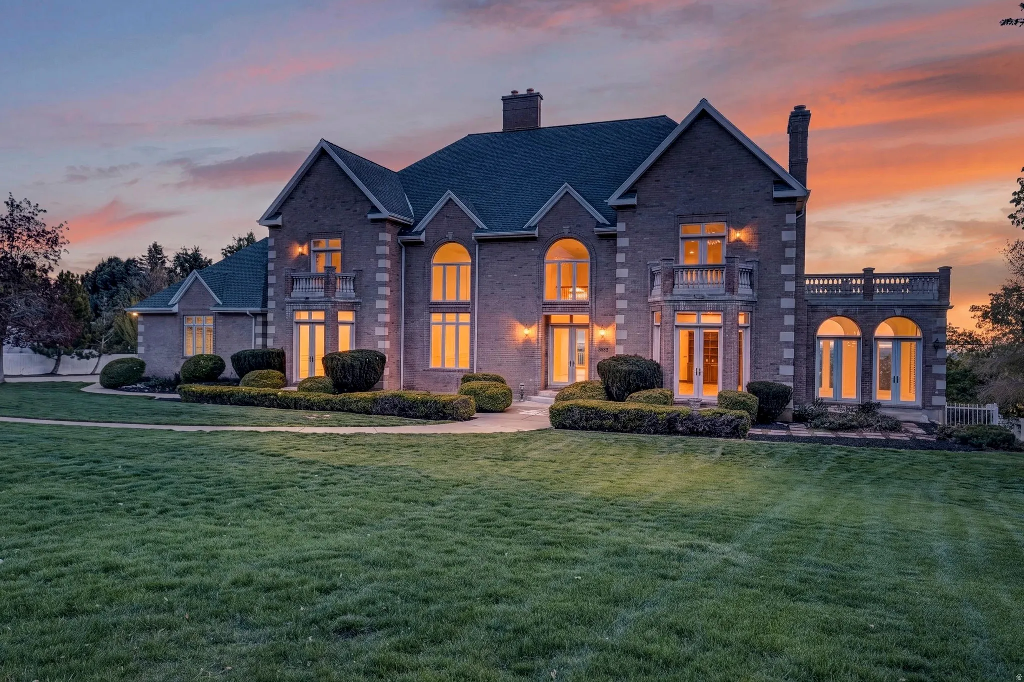 French Provincial style estate with a chimney, a lawn, and brick siding