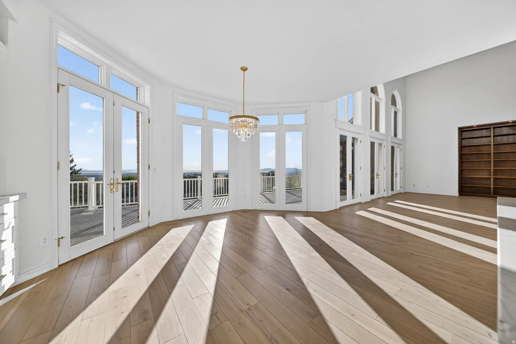 Breakfast nook with hardwood flooring, french doors, chandelier, and a high ceiling