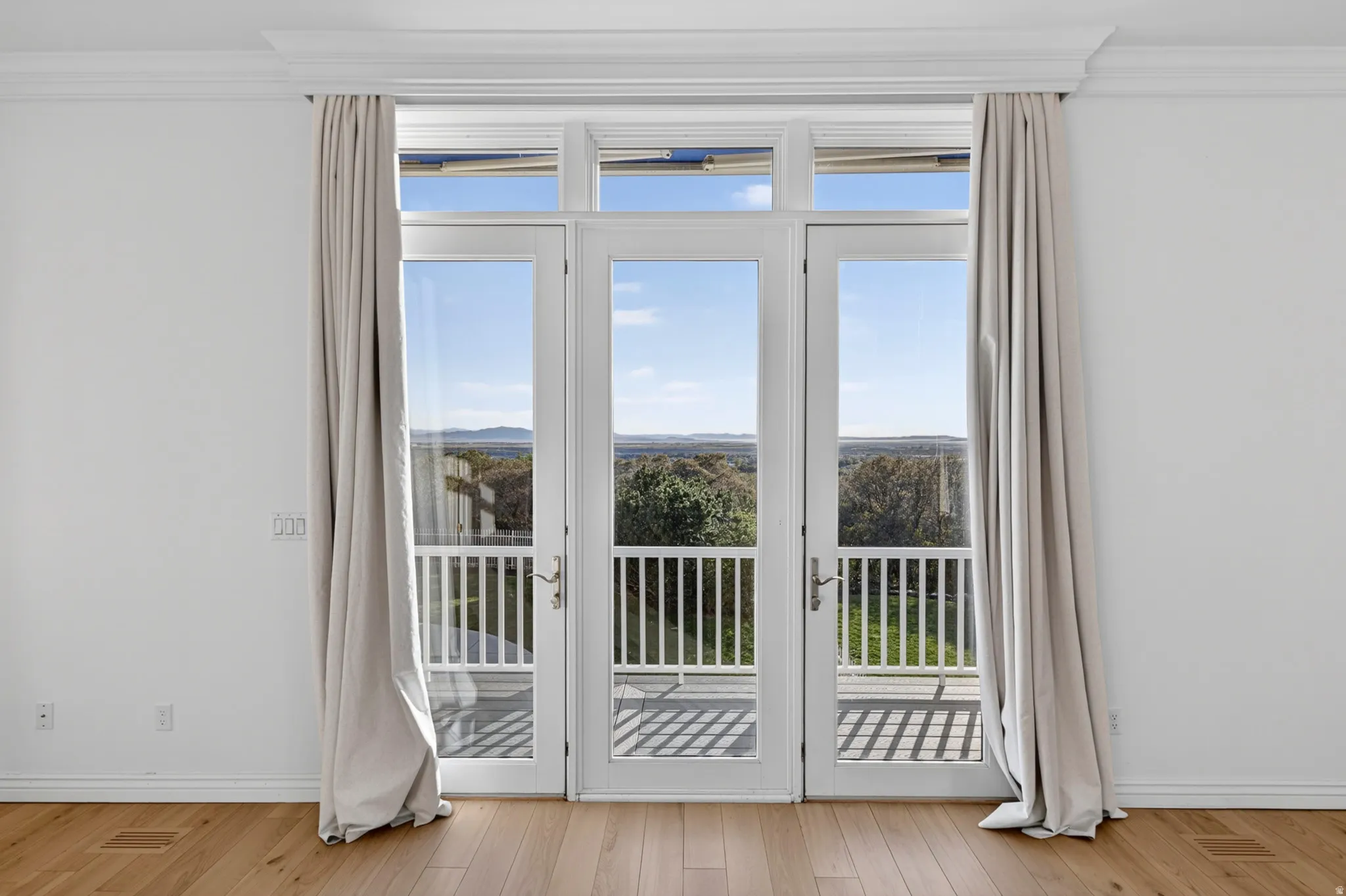 Doorway to outside featuring ornamental molding, plenty of natural light, and hardwood / wood-style floors