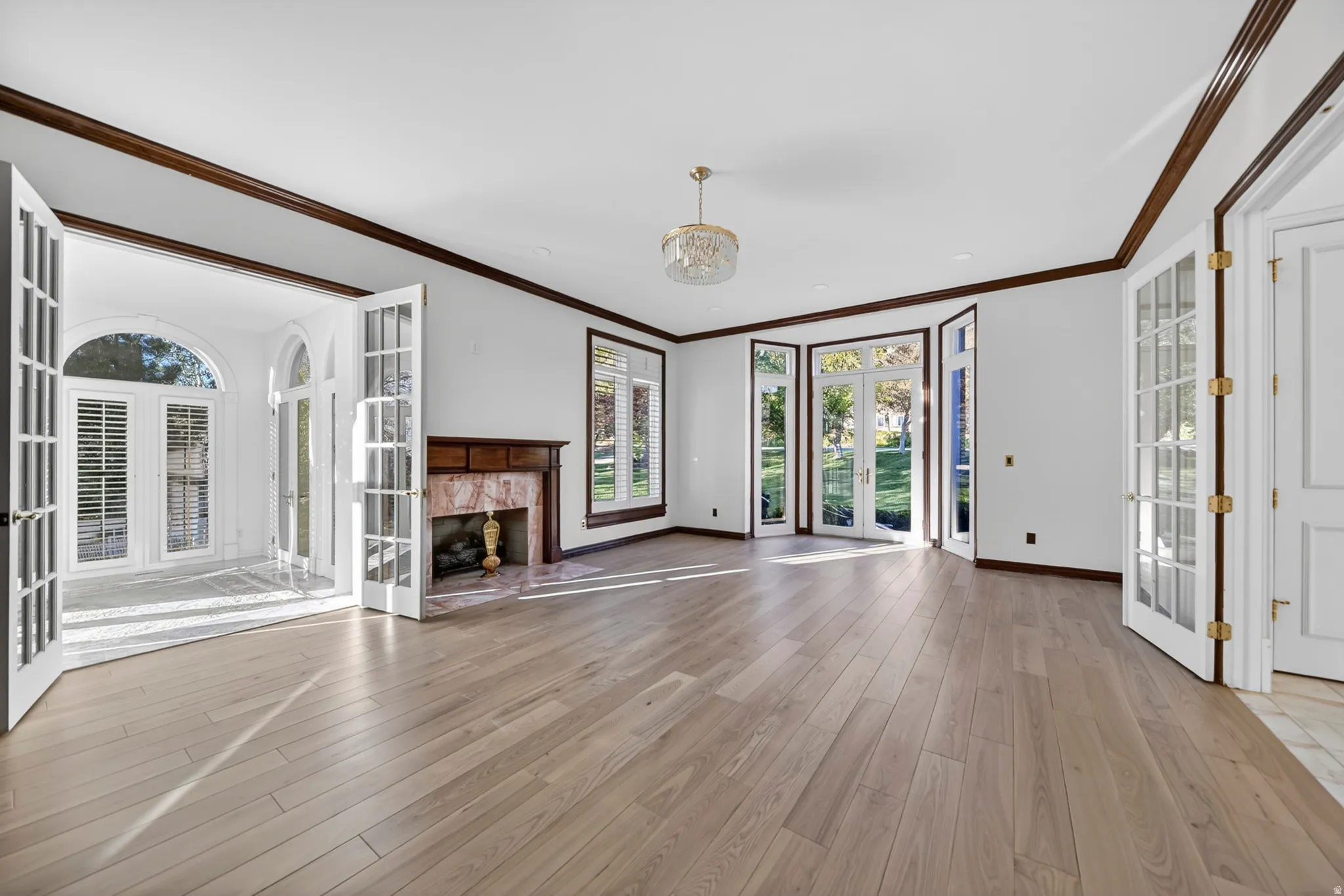 Study with french doors, crown molding, a high end fireplace, and hardwood flooring