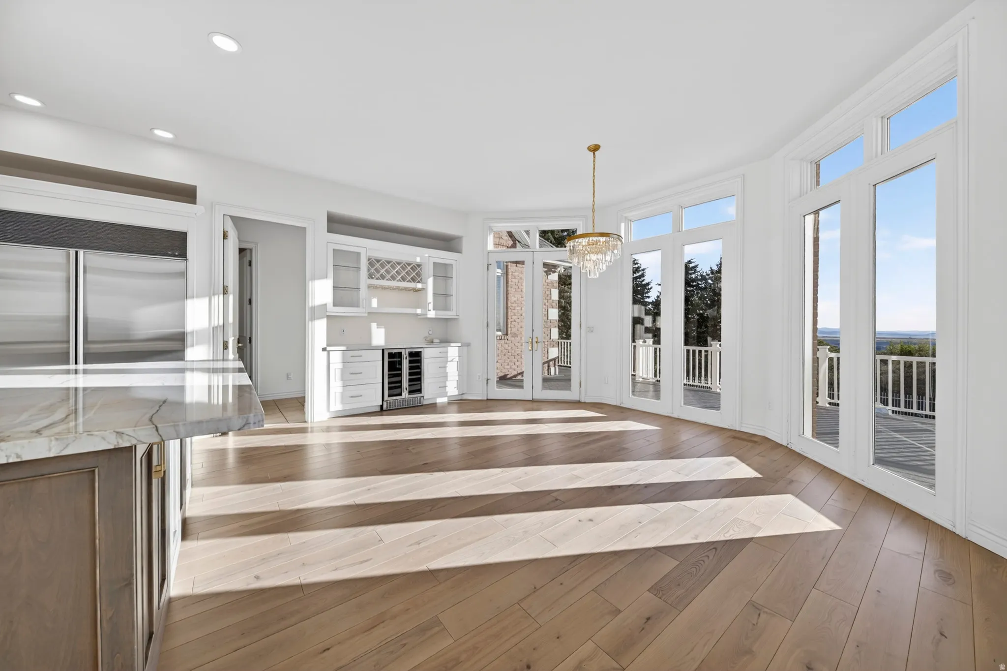 Kitchen with wine nook, breakfast nook, hardwood floors, beverage cooler, and recessed lighting