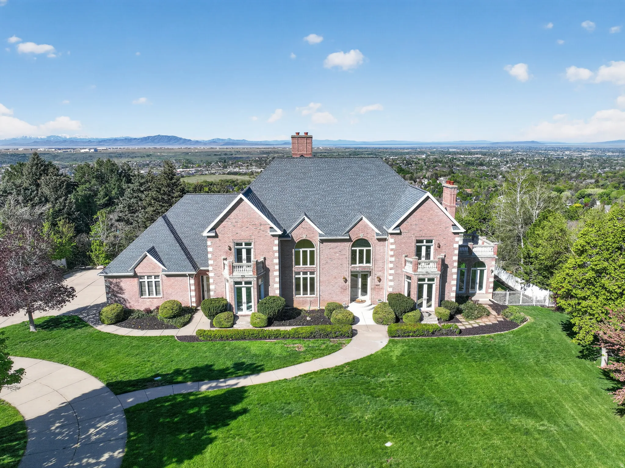 Traditional home featuring brick siding, a chimney, a front lawn, and a shingled roof