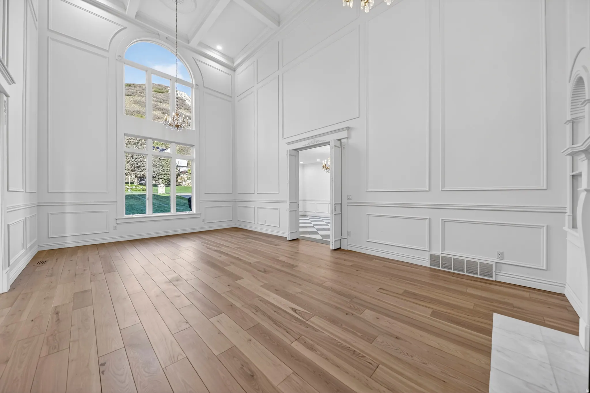 Parlor featuring a decorative wall, chandeliers, and hardwood flooring