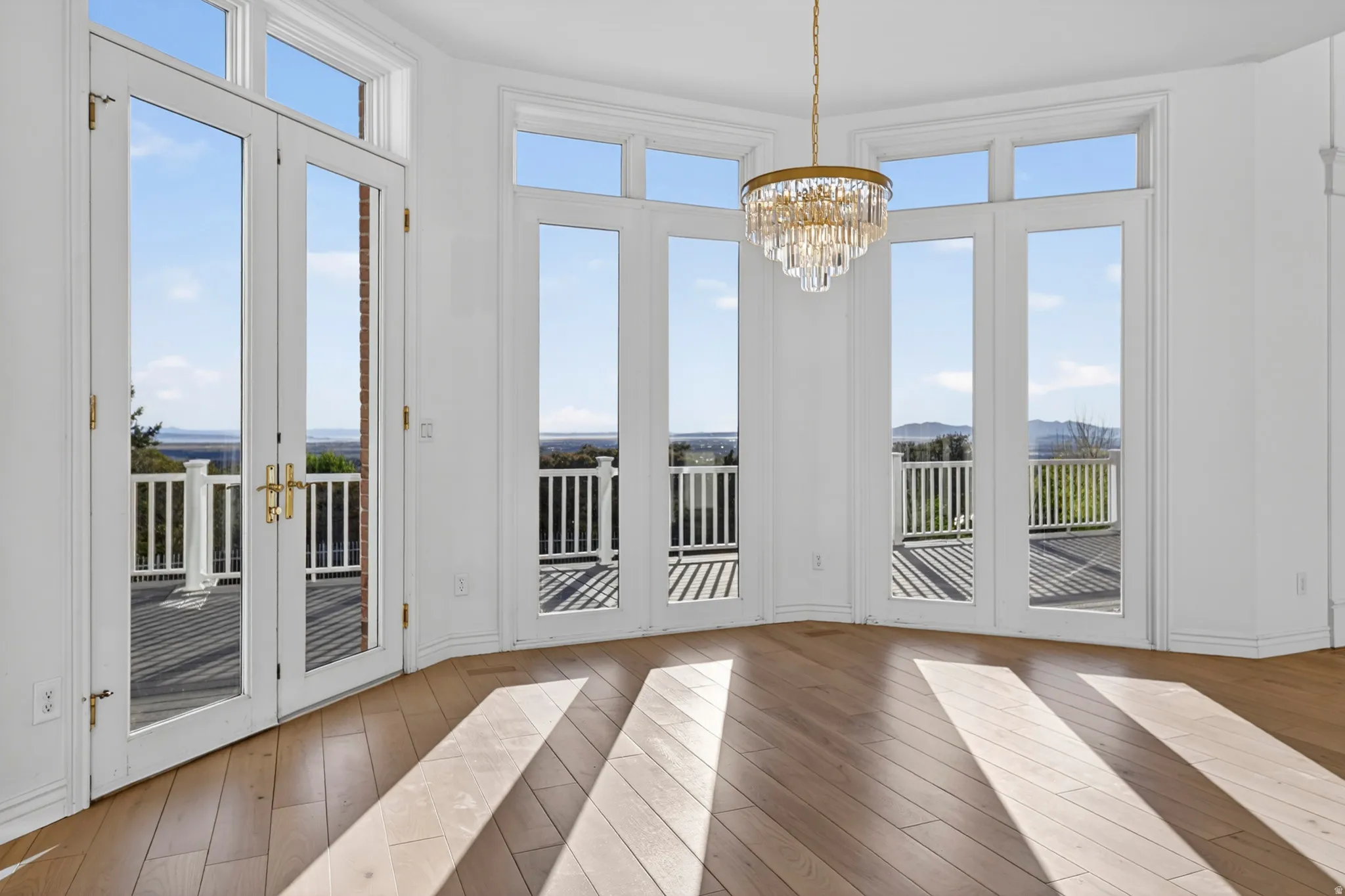 Breakfast nook and doorway to outside featuring hardwood flooring and a chandelier