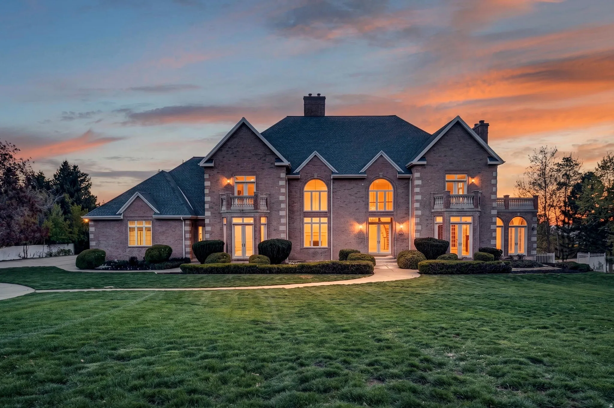 Traditional home with a chimney, a front lawn, brick siding, and a balcony