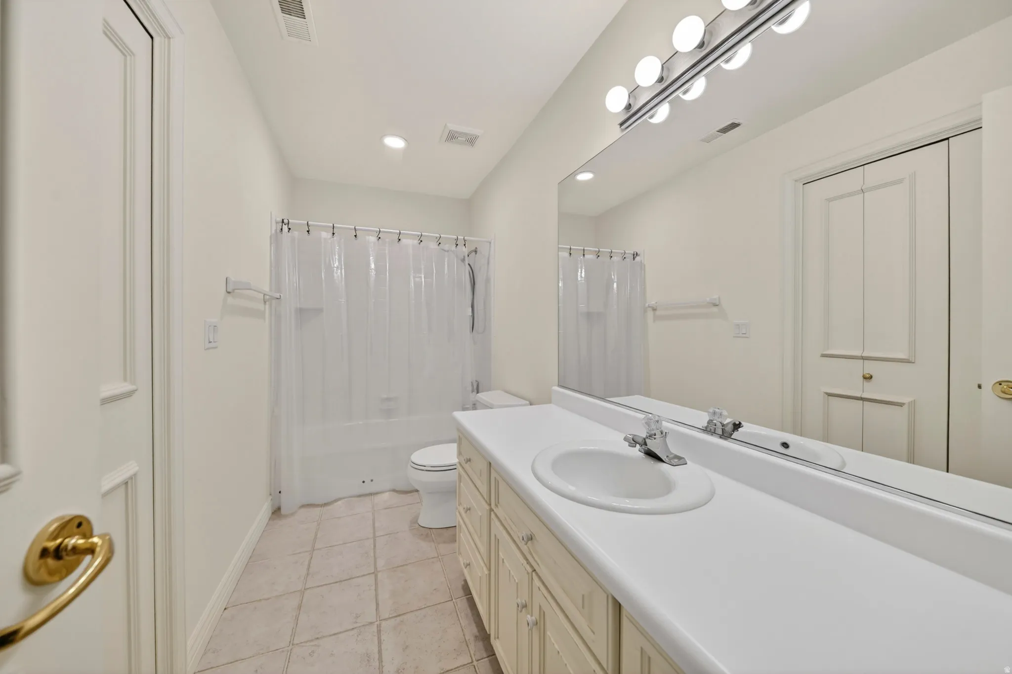 Full bath with vanity, light tile flooring, recessed lighting, and shower / tub combo