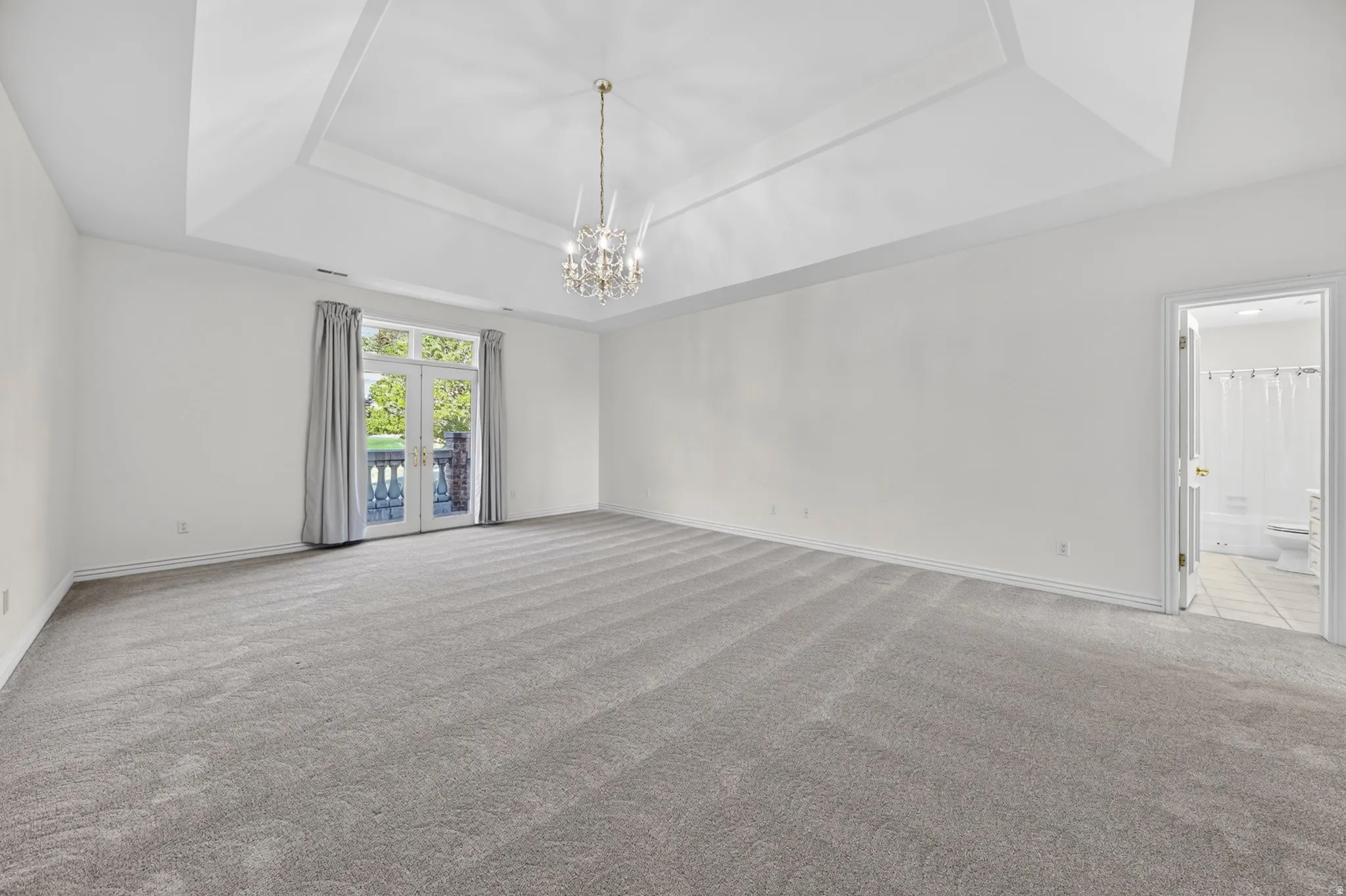 Bedroom with light carpet and chandelier