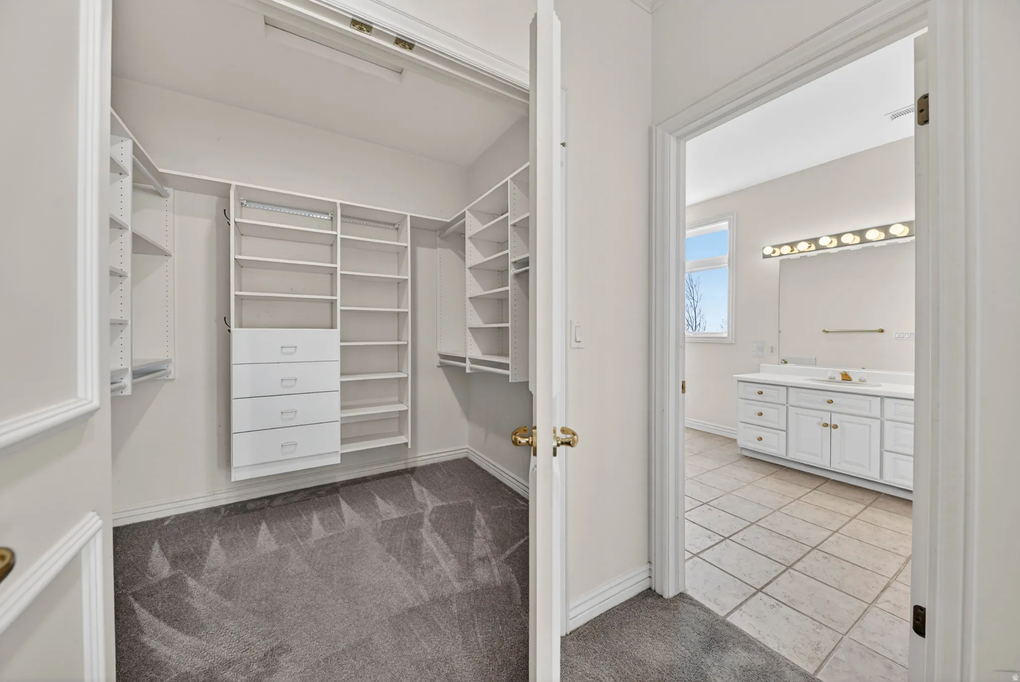 Walk in closet featuring light carpet and light tile floors