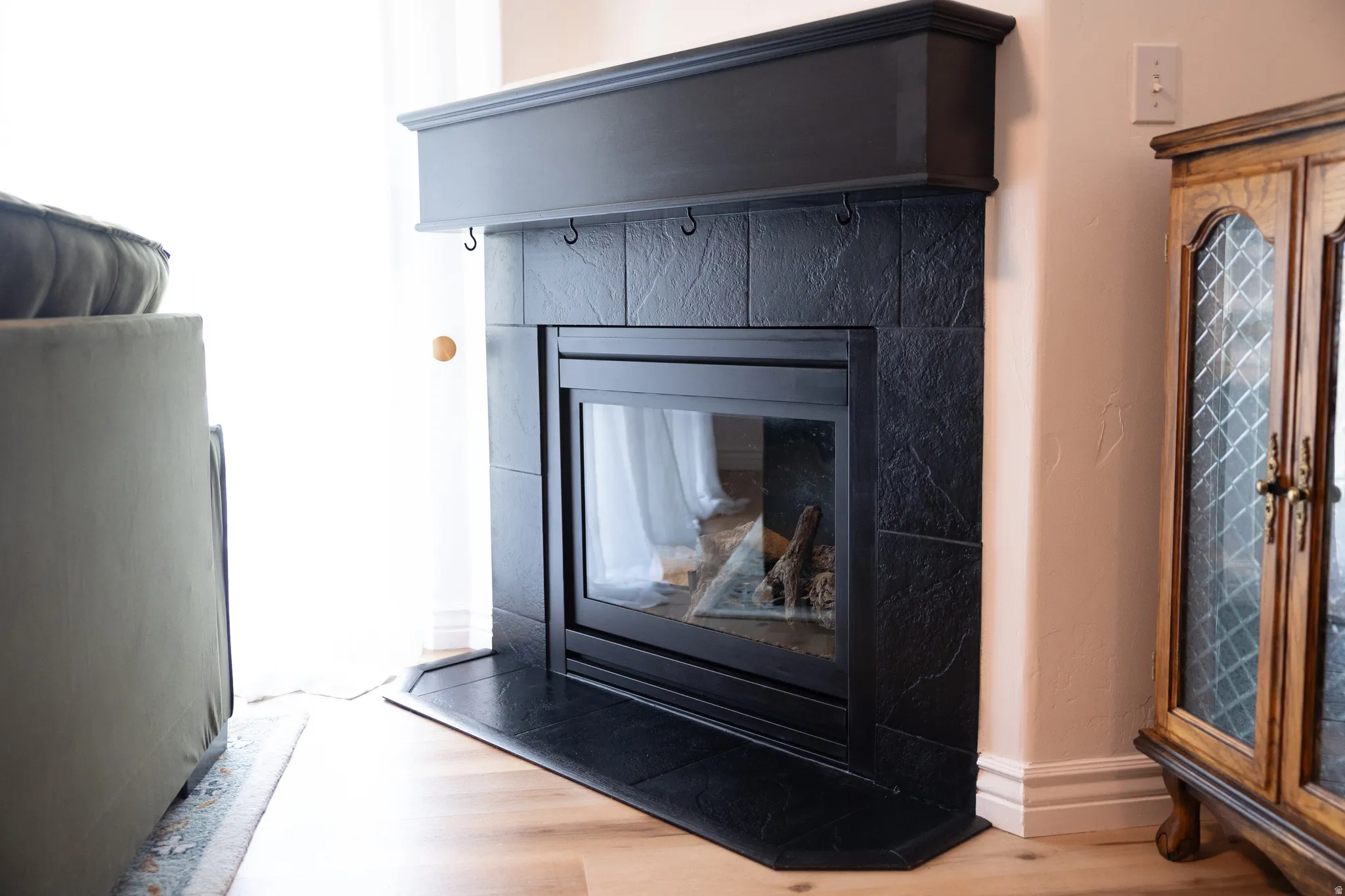 Detailed view of wood finished floors and a fireplace