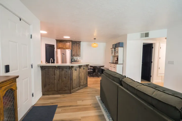 Kitchen with open floor plan, high quality fridge, light countertops, light wood-type flooring, and pendant lighting