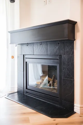 Detailed view of a tiled fireplace and wood finished floors